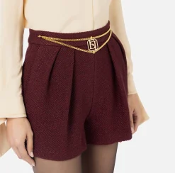 Short in tweed laminato con accessorio logo